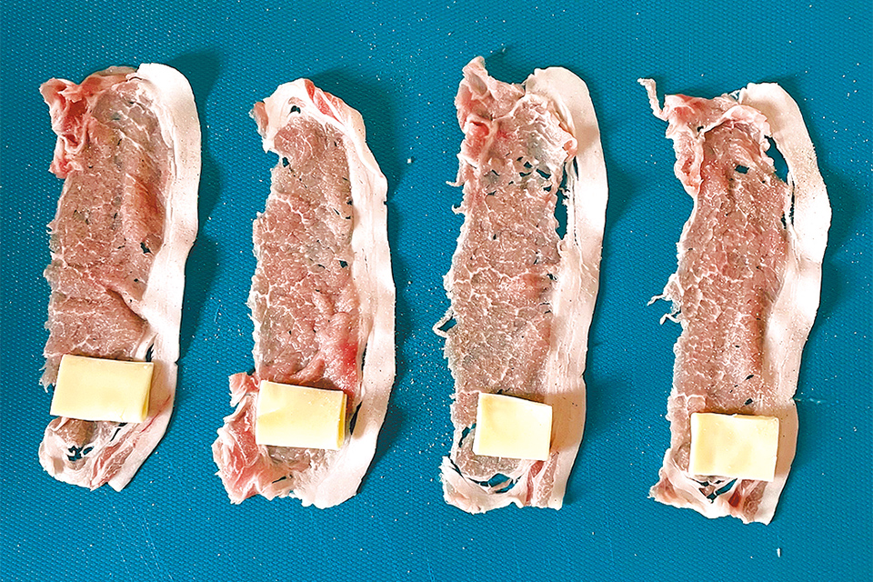 まな板などに豚肉を広げ軽く塩こしょうをふり、ベビーチーズをのせてクルクル巻く。